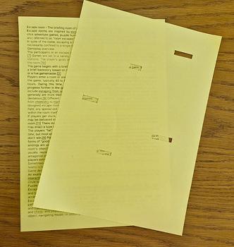 Paper message puzzle for escape room - hole-punched page revealing hidden message